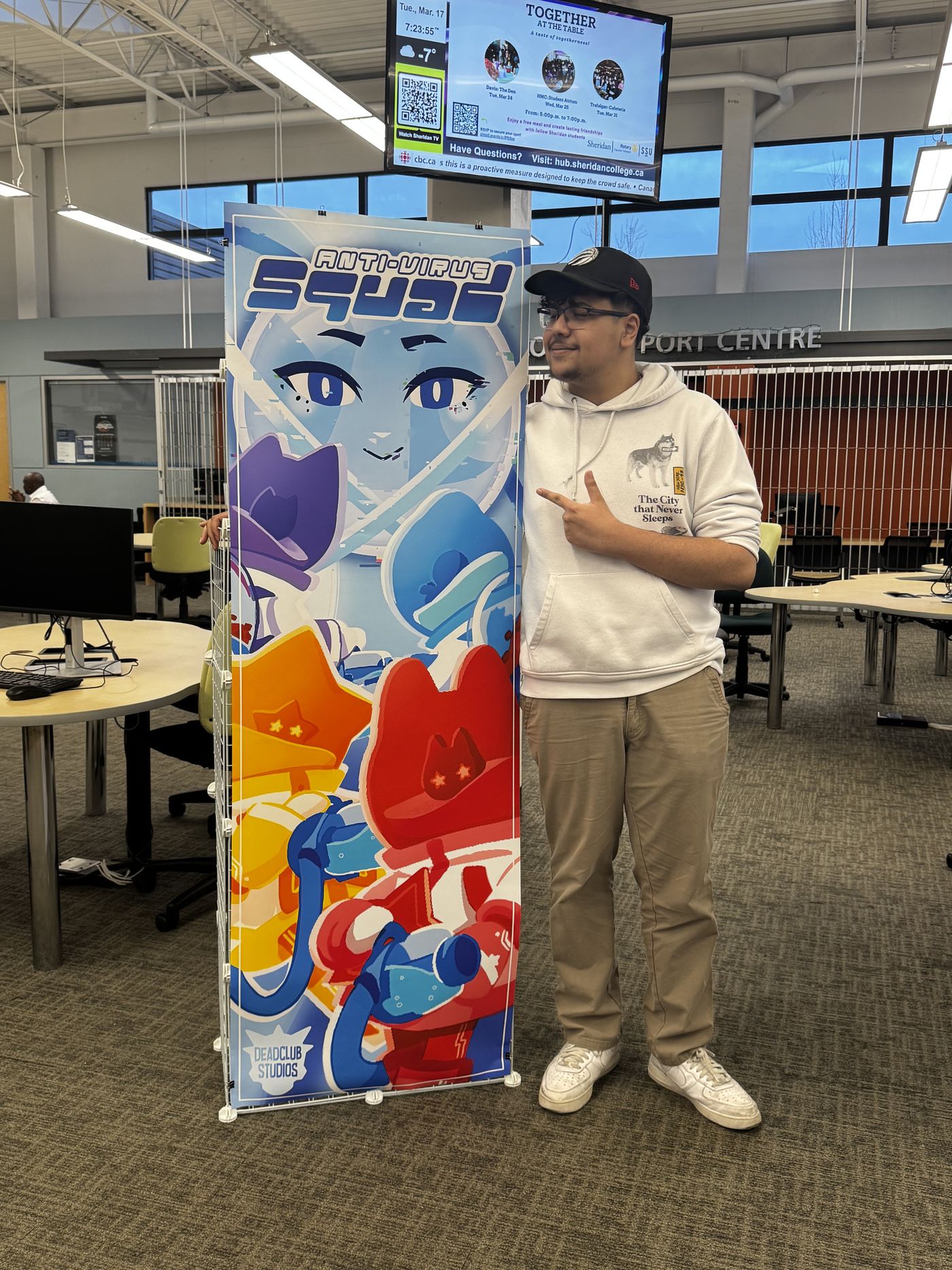 Marwan standing beside the MOM Anti-Virus Squad poster.